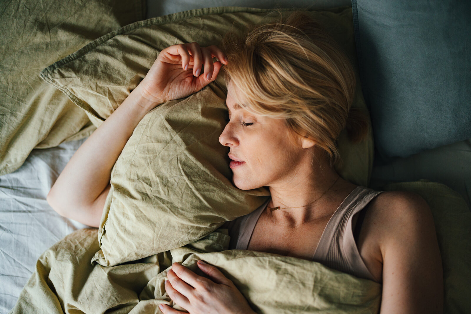 A woman asleep in bed in soft morning light